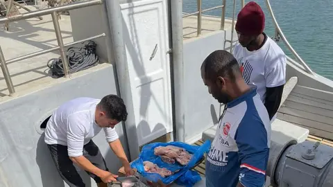 Imagen de uno de los pescadores de La Santa mostrando la forma de alimentar a las gambas.