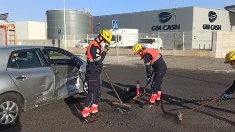 Los bomberos limpian los restos del accidente provocado en Playa Honda.