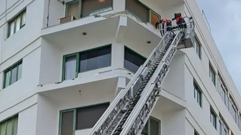 Imagen de los bomberos durante la actuación en la fachada afectada.