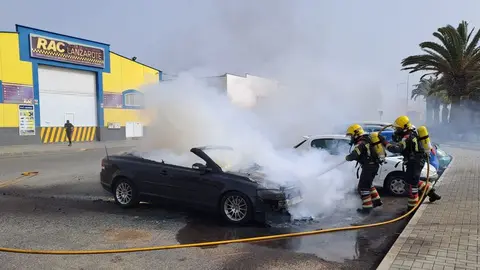 Imagen del momento de la actuación de los bomberos para apagar el fuego del coche.