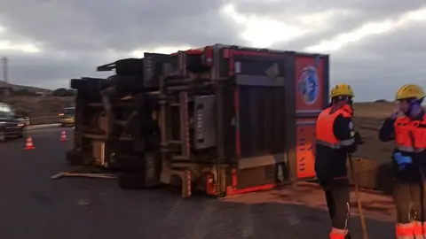 Imagen de los bomberos limpiando la zona del accidente.