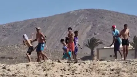 Imagen de los menores lanzando piedras. 