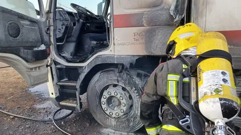 Momento en el que los bomberos se hicieron con el control del fuego en el cami&oacute;n