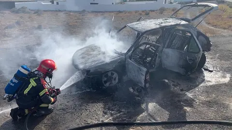 Bombero sofocando el fuego en el vehículo.
