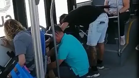 Imagen del pasajero y el chófer cerrando la puerta de la guagua.