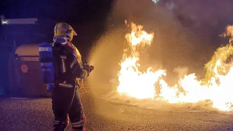 Uno de los bomberos empleándose a fondo en el incendio