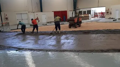 Imagen de los obreros asfaltando el terrero de lucha de Arrecife