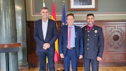 Enrique Espinosa con el consejero de Seguridad y Emergencias del Cabildo y el bombero galardonado.