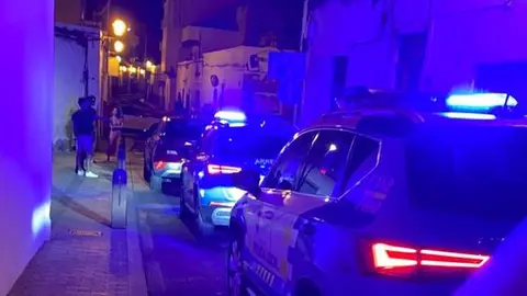 Momento en el que llegó la Policía Local y el inmigrante seguía delante del coche de alquiler