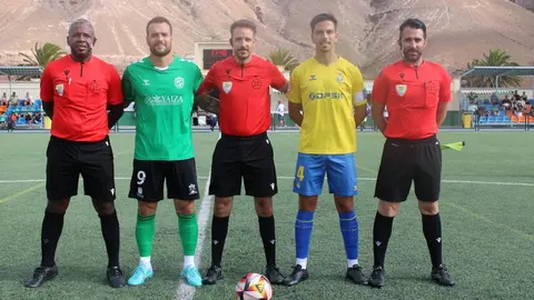 Imagen de los capitanes de los dos equipos con el trío arbitral