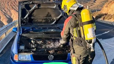 Imagen del bombero sofocando el fuego del motor