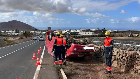Los bomberos con el vehículo cuando todavía se encontraba volcado