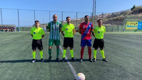 Los dos capitanes junto a los colegiados del encuentro