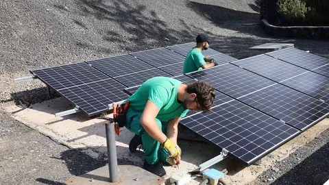 Alumnos de la escuela taller revisando la instalación de placas solares