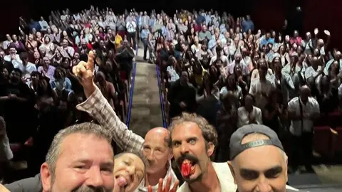 Los artistas con el entusiasmado público de fondo.