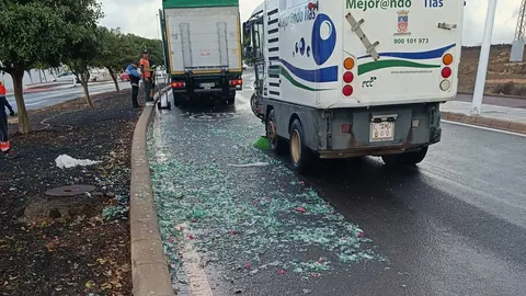 Imagen de la carretera llena de cristales tras producirse la caída de la carga.
