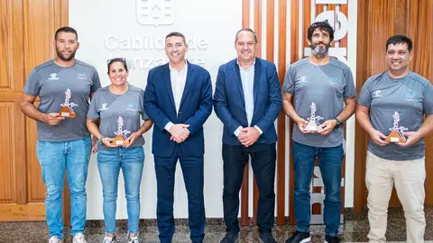 El presidente del Cabildo y el consejero de Deportes con la tripulación del barco ganador.