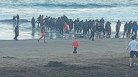 Llegada de los inmigrantes a la playa de La Garita mientras se encontraban varias personas disfrutando de la tarde.