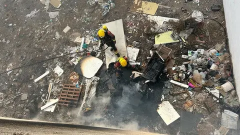 Los bomberos en el fondo del edificio actuando sobre el incendio