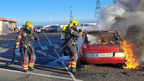 Momento de la llegada de los bomberos para apagar el fuego del vehículo