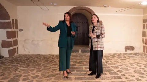 Olivia Duque explicando a Migdalia Machín la situación del edificio.