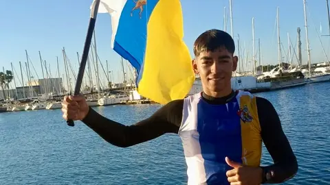 Alonso Pérez celebrando su triunfo con la bandera canaria.