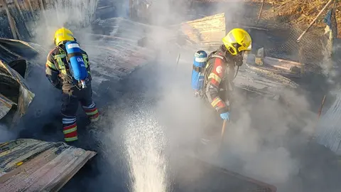 Bomberos apagando el fuego en el corral de Tinajo.