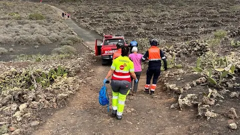 Bombero del Consorcio de Seguridad y personal sanitario acompañando a la turista afectada.