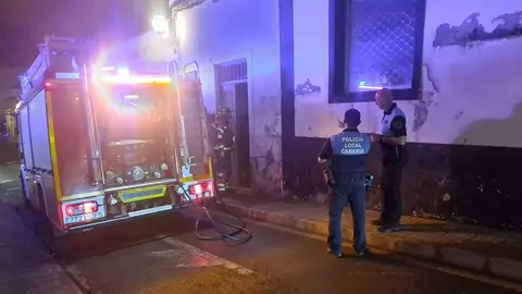 Imagen del momento de la actuación de los bomberos en la vivienda en presencia de agentes de la Policía Local