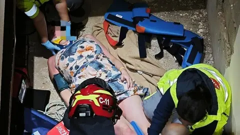 Los bomberos rescatan a la mujer precipitada en Playa Blanca.
