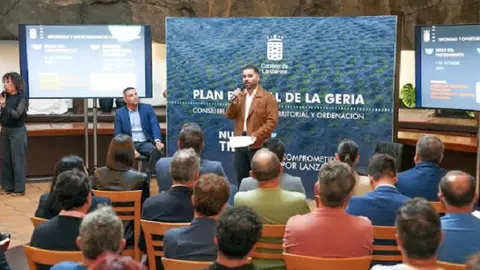 Imagen de la presentación del Plan con el consejero Jesús Machín interviniendo y el presidente del Cabildo, Oswaldo Betancort, escuchando atento. 