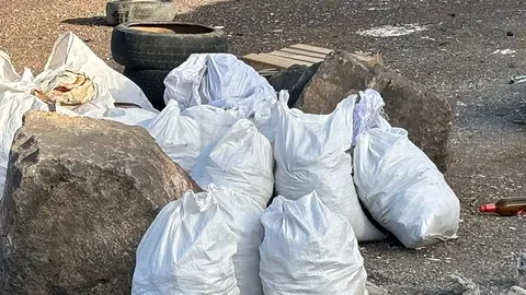 Imagen con las sacas de escombros arrojadas junto a contenedores de basura en un barrio de la capital de Lanzarote 