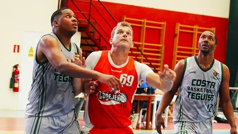 Jugadores del equipo de Costa Teguise cerrando el rebote ante el jugador del Conejeros.