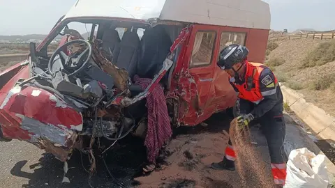 Uno de los bomberos del Consorcio retirando restos de la furgoneta siniestrada