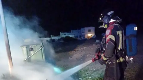 Un contenedor sofoca el incendio de un contenedor en Playa Quemada.
