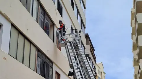 Imagen de uno de los bomberos accediendo a la vivienda por la ventana