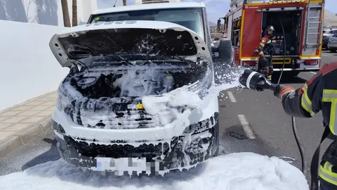 Bomberos del Consorcio apagando el fuego localizado en el motor del vehículo lanzando espuma.