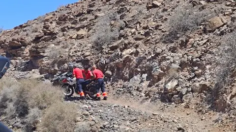 Los bomberos recogiendo la moto de montaña