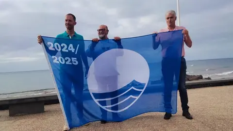 Representante del Ayuntamiento de Tías junto a la bandera azul.