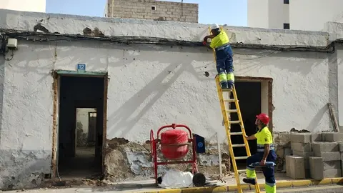 Operarios del Servicio de Alumbrado del Ayuntamiento de Arrecife desconectan el 'enganche de los okupas para robar electricidad del alumbrado público. Material para el cerramiento de la casa