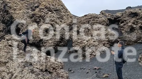 Imagen de la mujer turista subida a una piedra para realizar la fotorgrafía en un espacio protegido. (1)