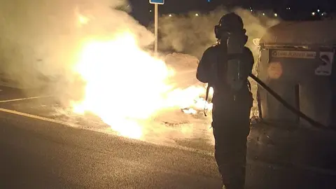 Un bombero extingue el fuego de los contenedores en Arrecife.