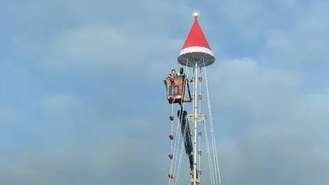 Imagen de los trabajadores subidos en una grúa a una gran altura.