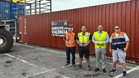 Yonathan de León y Kevin Cortés, junto a efectivos de Protección Civil, hoy en el puerto de Los Mármoles. De fondo el contenedor con ayuda humanitaria para Valencia