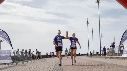 Un hombre y una mujer entran de la mano en la meta