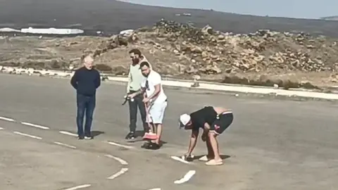 Imagen de este lunes de los integrantes de las autoescuelas pintando el circuito para poder examinar a la gente. 