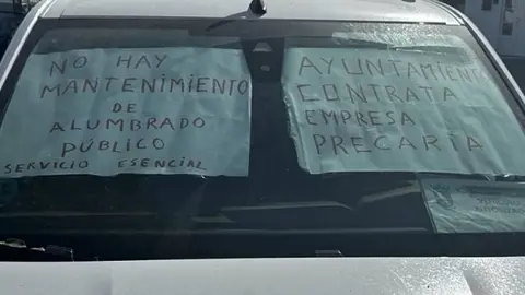 Carteles de protesta de los trabajores de la empresa de alumbrado de Tías en un vehículo.