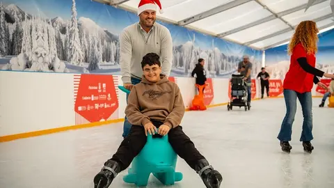 Yonathan de León junto a uno de los niños en la pista de hielo durante la jornada inclusiva de Navilan.