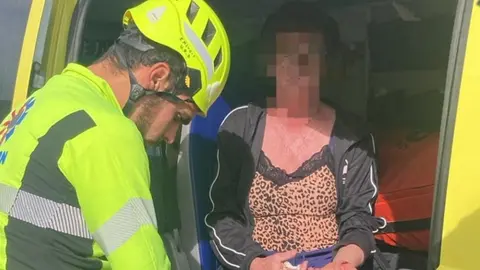 Mujer siendo atendida por un operario de EMERLAN.