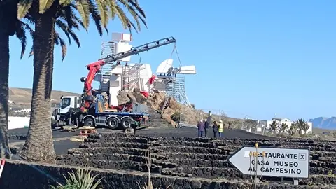 Operarios del Cabildo de Lanzarote realizando las labores de colocación de los fragmentos rehabilitados del Monumento al Campesino.